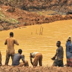 Artisanal miners wash at a rudimentary dam on the site, where excess water is pumped into © Guy Oliver / IRIN